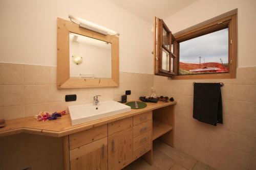 uma casa de banho com um lavatório e um espelho em Sponda Ski in- Ski out Mt 50 - Happy Rentals em Livigno
