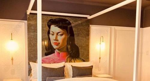 a painting of a woman on the wall of a bedroom at Cellar In Town in Robertson