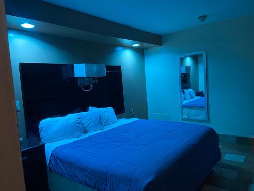 a blue room with a bed and a mirror at Circle Motor Lodge in South Amboy