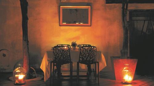 a table with chairs and lights in a room at Kókkini Porta Rossa in Rhodes Town