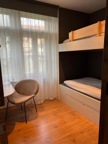 Chalet Mignon - your vacation oasis at Lake Brienz في بونيغن: غرفة نوم مع سرير بطابقين وكرسي ومكتب