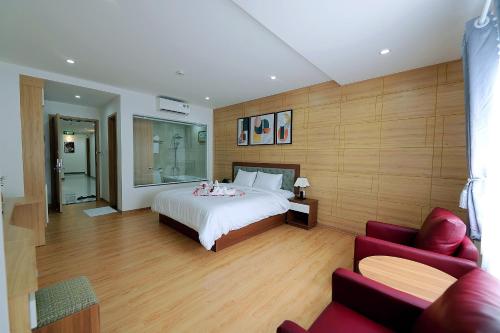 a bedroom with a bed and a living room at Khách sạn Xà Nu in Kon Tum