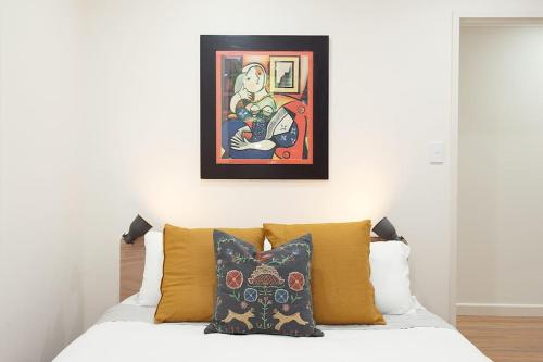 um quarto com uma cama com um quadro na parede em Huge 3 Bed Camperdown Garden Apt w Parking Aircon em Sydney