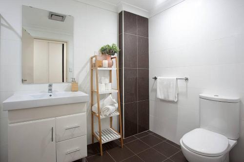 a bathroom with a sink and a toilet and a mirror at Huge 3 Bed Camperdown Garden Apt w Parking Aircon in Sydney