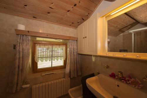 bagno con lavandino, finestra e vasca di Azalea - Happy rentals a Livigno