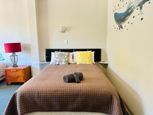 a bedroom with a bed with two stuffed animals on it at A1 Kaikoura Motel & Apartment in Kaikoura