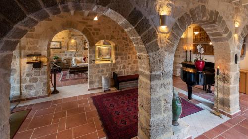 a room with a stone archway with a piano at Kókkini Porta Rossa in Rhodes Town