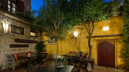 a restaurant with tables and chairs and a tree at Kókkini Porta Rossa in Rhodes Town