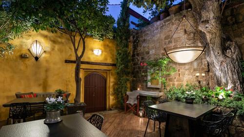 a restaurant with tables and chairs and a tree at Kókkini Porta Rossa in Rhodes Town