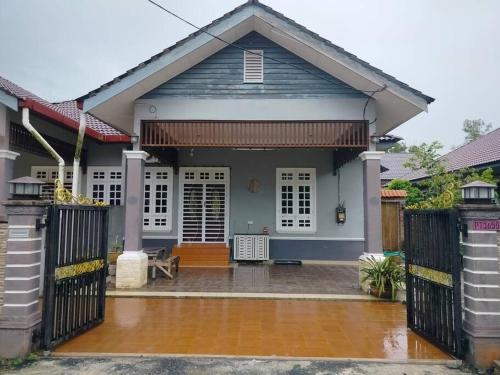 uma casa com um portão em frente em Rumah Tamu Firdaus em Marang