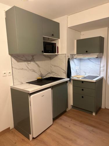 una pequeña cocina con electrodomésticos verdes y blancos en Appart 500 m centre ville - gare, en Soissons