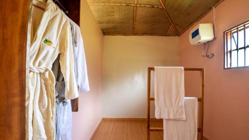 un bagno con accappatoio appeso al muro di Lake Chahafi Resort a Kisoro