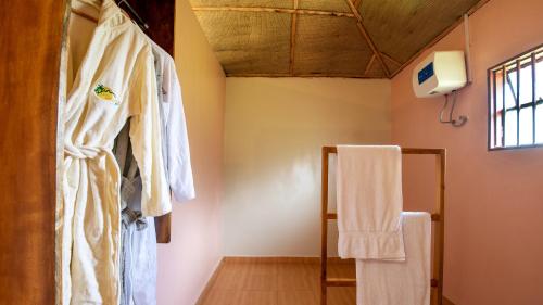 a bathroom with a robe hanging on the wall at Lake Chahafi Resort in Kisoro