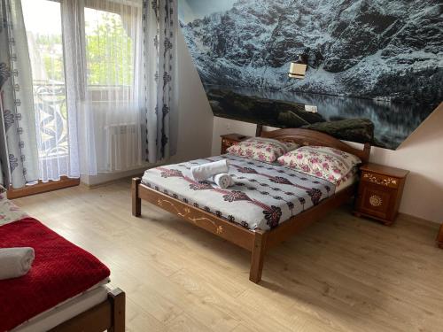 a bedroom with a bed and a painting on the wall at Pokoje u Wojtanka-zniżki na termy in Białka Tatrzańska