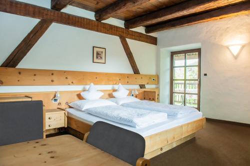 a bedroom with a large bed and a table at B&B Unterhabsbergerhof in Appiano sulla Strada del Vino
