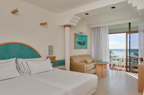 コスタ・カルマにあるMeliá Fuerteventuraのベッドルーム1室(ベッド1台付)、リビングルームが備わります。