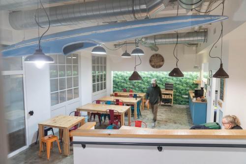 a man walking into a restaurant with tables and benches at Koba Hostel in Donostia-San Sebastián