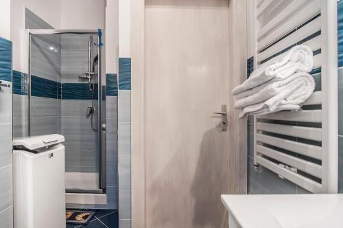 y baño con ducha y toallas en un estante. en Domus Hormiae, en Formia