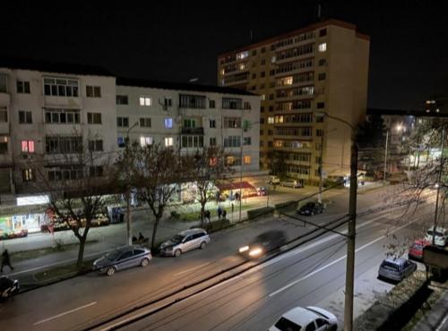 a city street at night with cars and buildings at Studio 100G in Târgovişte