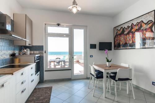 cocina con mesa y vistas al océano en Domus Hormiae, en Formia