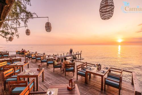 ein Restaurant am Strand mit Sonnenuntergang in der Unterkunft Camia Resort & Spa in Phu Quoc