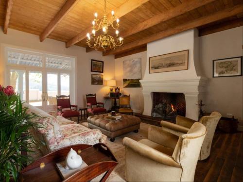 a living room with a chandelier and a fireplace at Banhoek Corner Guesthouse in Stellenbosch