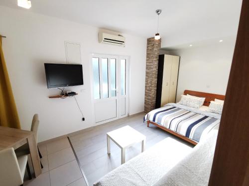 1 dormitorio con 1 cama y TV en la pared en Sea Star Kumbor, en Kumbor