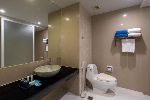 a bathroom with a sink and a toilet and a mirror at Arinara Beach Resort Phuket - SHA Extra Plus in Bang Tao Beach