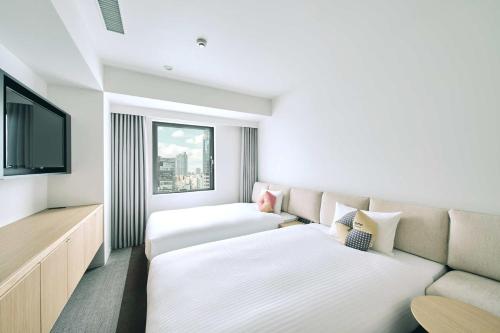Habitación de hotel con 2 camas y sofá en OMO3 Tokyo Akasaka by Hoshino Resort en Tokio