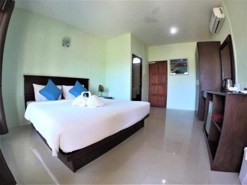 a bedroom with a large white bed with blue pillows at Veranda Lanta Resort in Ko Lanta