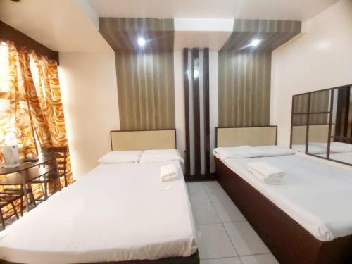 a bedroom with two beds and a table at OYO 924 Cosmo Hotel Espana Near Ust in Manila