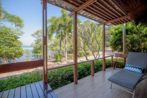 a porch with a chair and a view of the water at Seashell Village Resort in Chao Lao Beach