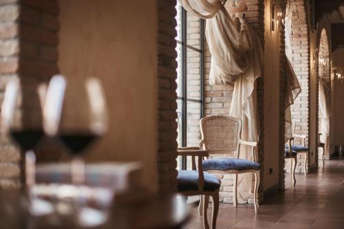 um quarto com uma mesa, uma cadeira e uma janela em Agriturismo Tenuta La Romana em Nizza Monferrato