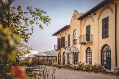 a building with tables and chairs in a courtyard at Agriturismo Tenuta La Romana in Nizza Monferrato