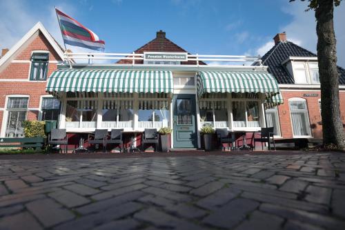 a building with a porch with tables and chairs at Pension Westerburen in Schiermonnikoog