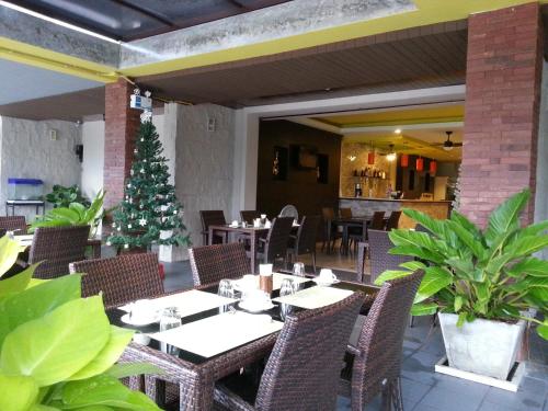 a restaurant with a christmas tree and tables and chairs at Purimas Resortel in Rawai Beach