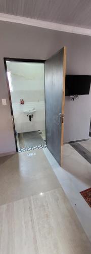 ein leeres Zimmer mit einer Tür und einem Waschbecken in der Unterkunft New apollo lodge in Roodepoort