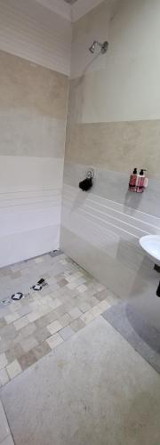 Dieses weiße Zimmer verfügt über eine Badewanne und einen Boden. in der Unterkunft New apollo lodge in Roodepoort