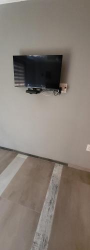 einen Flachbild-TV auf einer weißen Wand in der Unterkunft New apollo lodge in Roodepoort