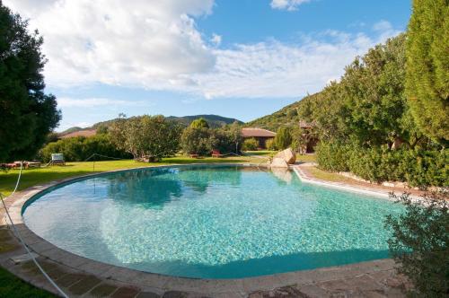 a large swimming pool in a yard with trees at Hotel Spartivento in Chia
