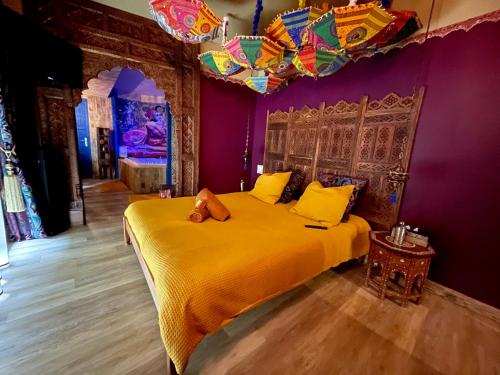 a bedroom with a yellow bed with a purple wall at Chambre & Spa "La Casa Blue" in Wingles