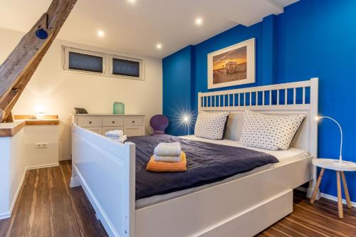 een slaapkamer met blauwe muren en een bed bij null Haus Achtern Poggendiek, Whg Spatzennest, OG in Sankt Peter-Ording