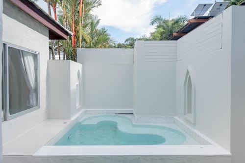 a swimming pool in the middle of a white building at Seashell Village Resort in Chao Lao Beach
