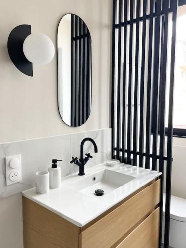 ein Badezimmer mit einem Waschbecken, einem Spiegel und einem WC in der Unterkunft Appartement calme centre ville rénovation récente in Le Touquet-Paris-Plage