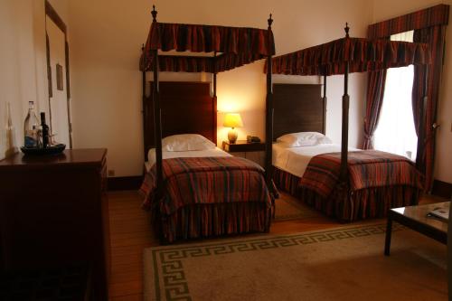 a hotel room with two beds and a window at Pousada Mosteiro de Guimaraes in Guimarães