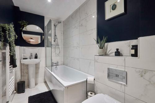 La salle de bains est pourvue d'une baignoire, d'un lavabo et de toilettes. dans l'établissement Homebird Property - Mill Cottage, à Leeds