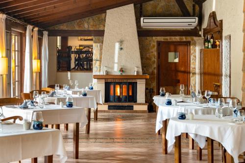a dining room with white tables and a fireplace at Posada d' Es Molí in Playa de Palma