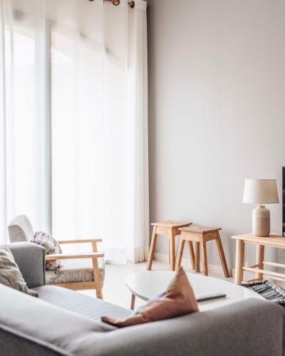 a living room with a couch and a large window at Can Alemany in Santa Margarida de Montbui