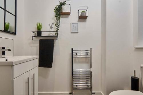 baño con lavabo y estante con plantas en la pared en Homebird Property - Salisbury House en Leeds