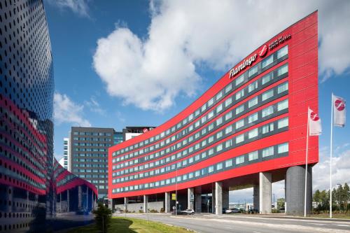 a red hotel building in a city at Break Sokos Hotel Flamingo in Vantaa